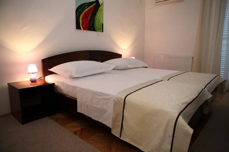 Une chambre lumineuse avec un grand lit recouvert d'une courtepointe blanche.