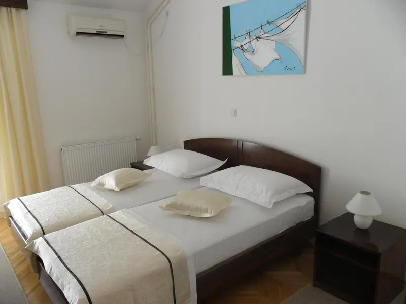 Une chambre lumineuse avec deux lits simples et une décoration murale.