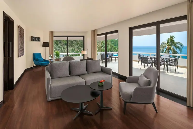 Espace de vie lumineux avec canapé et accès à une terrasse ensoleillée.
