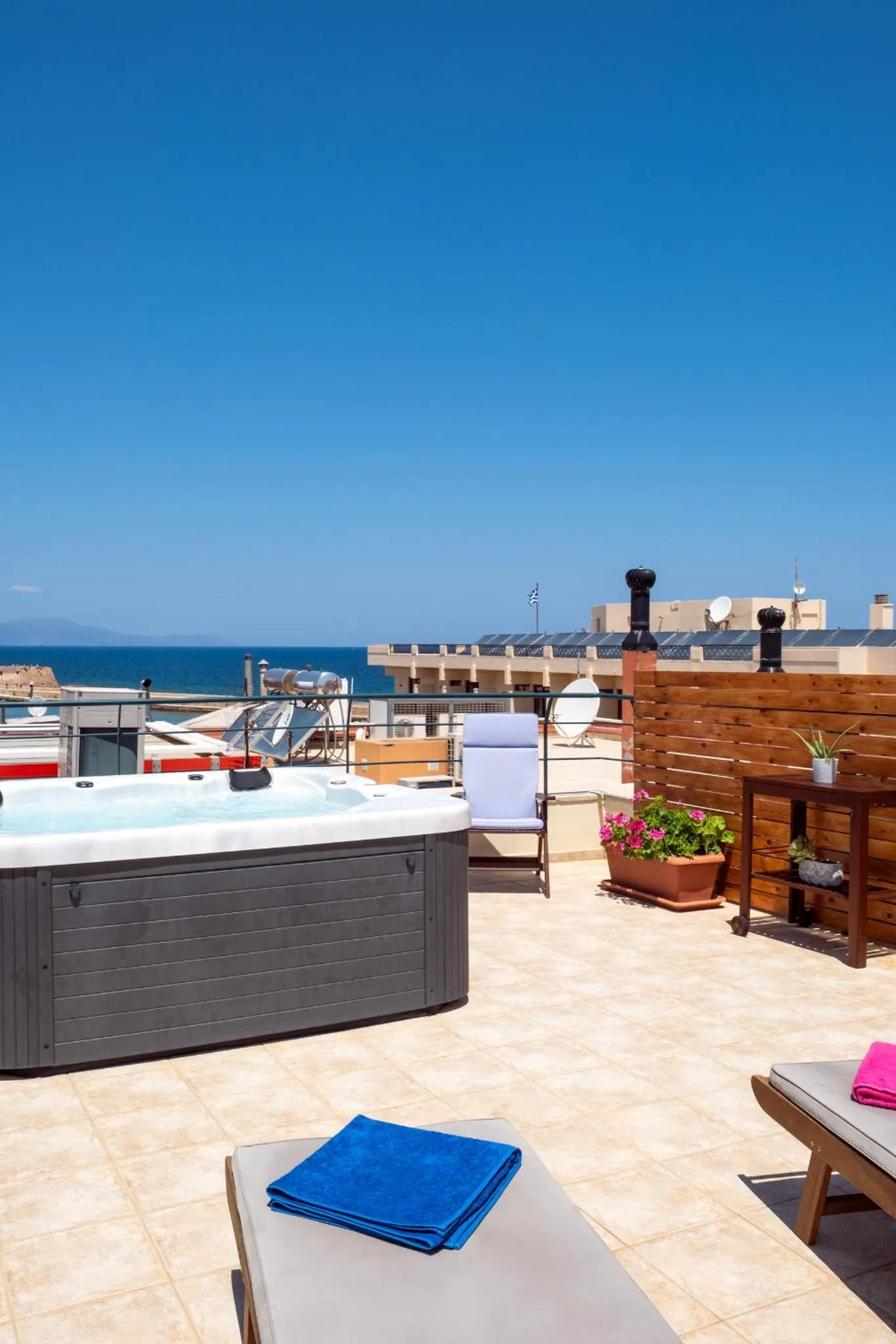 Terrasse avec jacuzzi et mobilier de détente offrant une vue sur la mer.