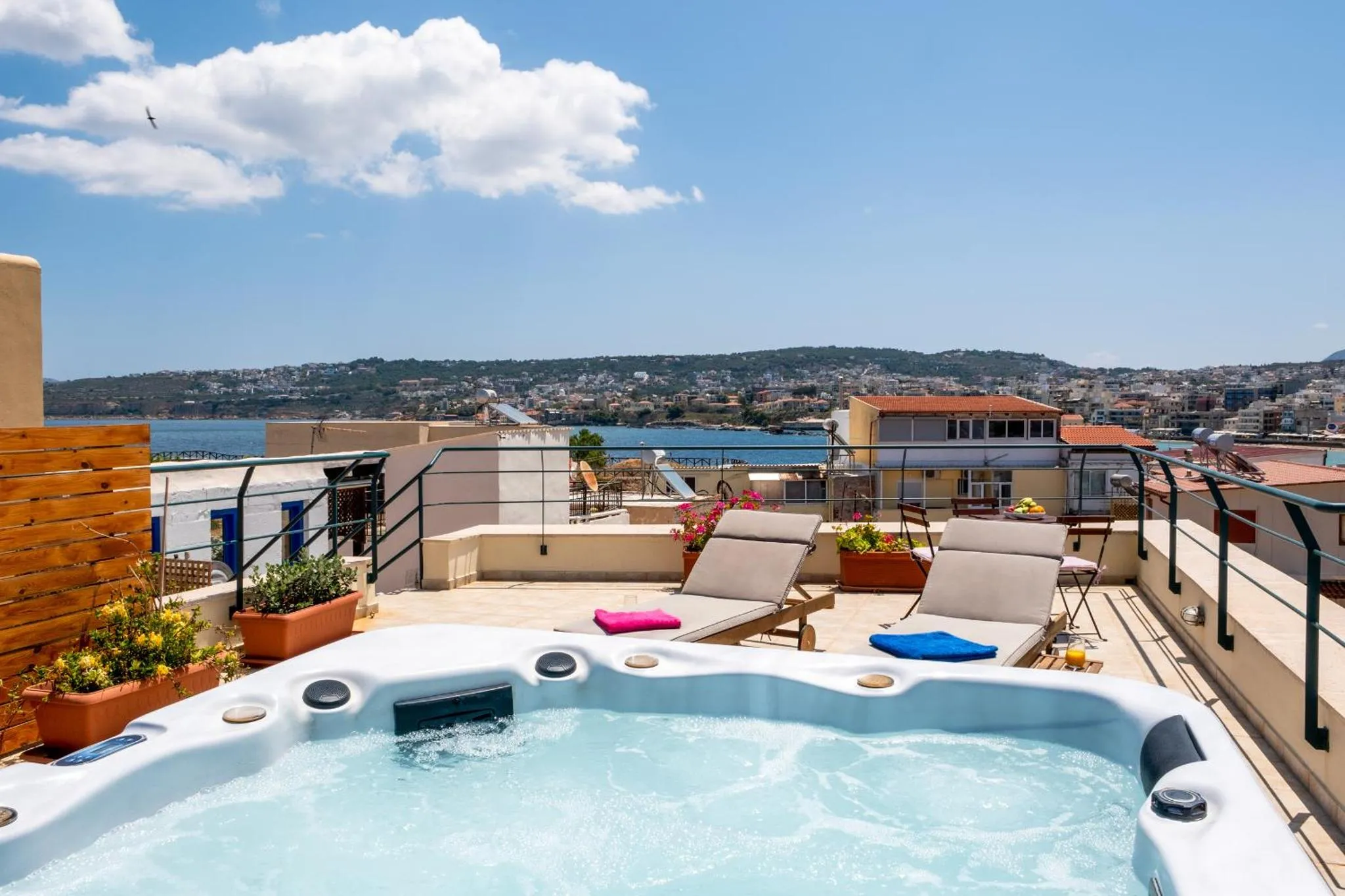 Terrasse avec jacuzzi et vue sur la mer et la ville.