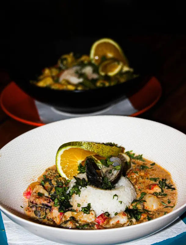 Un plat de fruits de mer est présenté dans une assiette blanche.