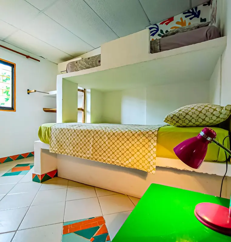 Une chambre avec un lit superposé et une décoration colorée.