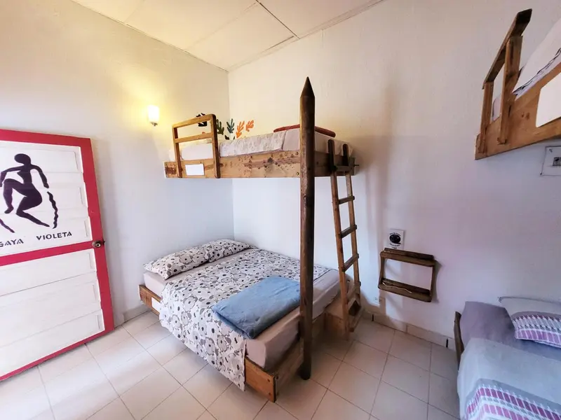 Une chambre avec un lit superposé et un lit simple.