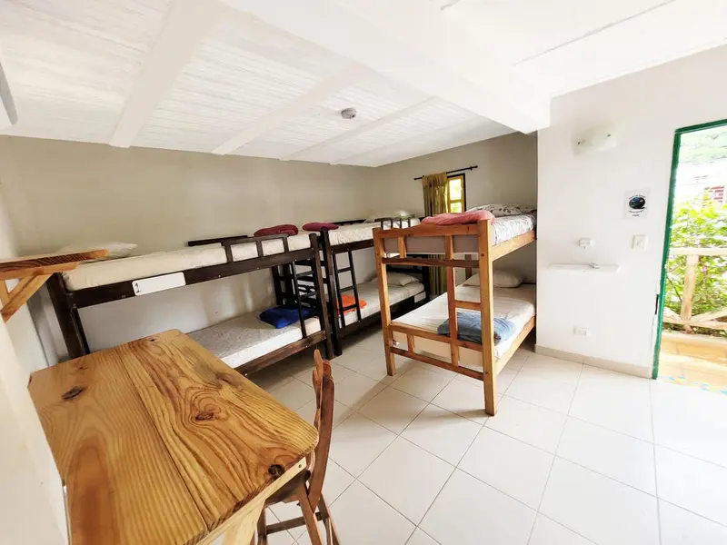 Une chambre avec plusieurs lits superposés et une table en bois.