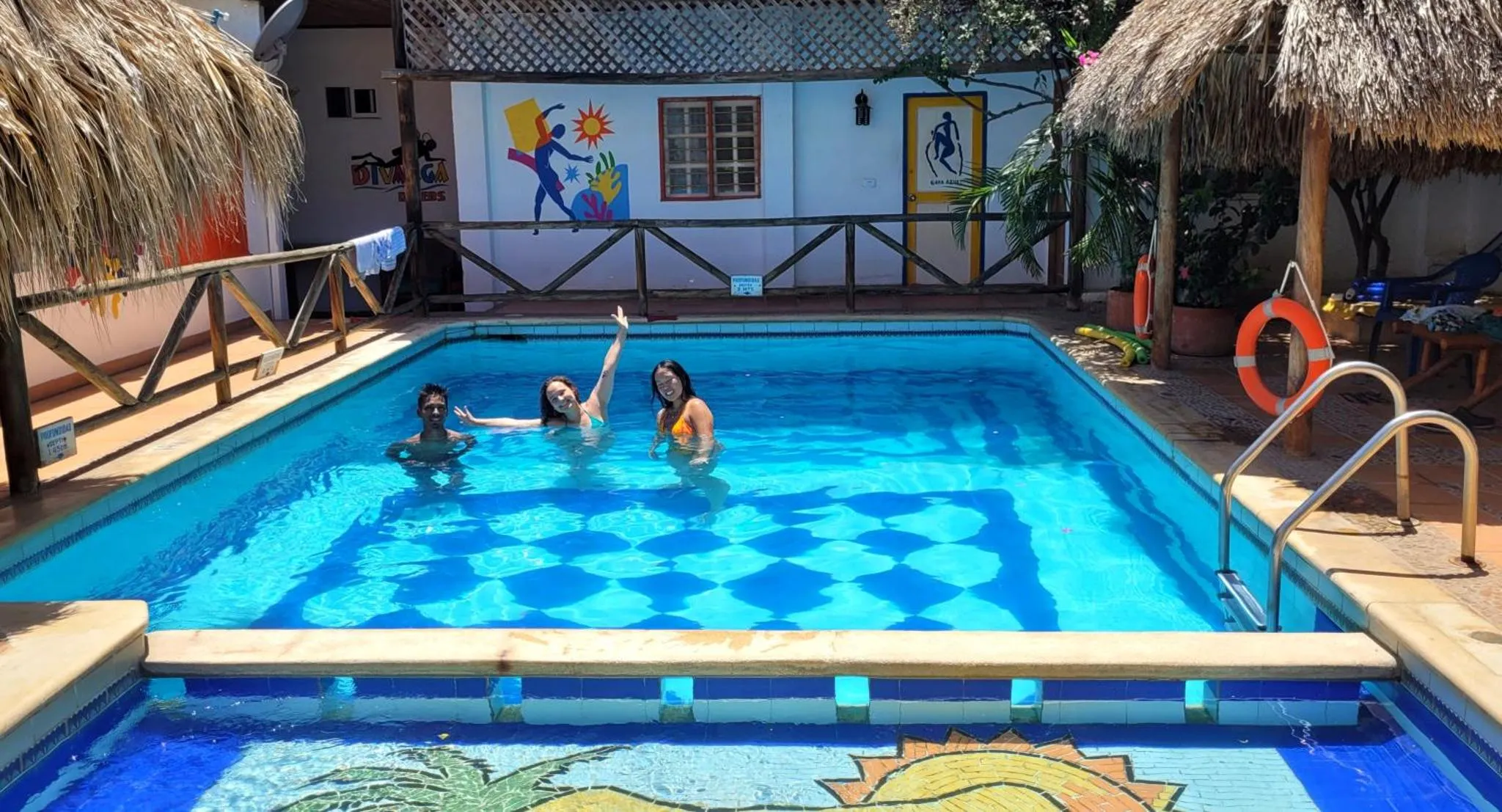 Des personnes se détendent au bord d'une piscine carrelée.