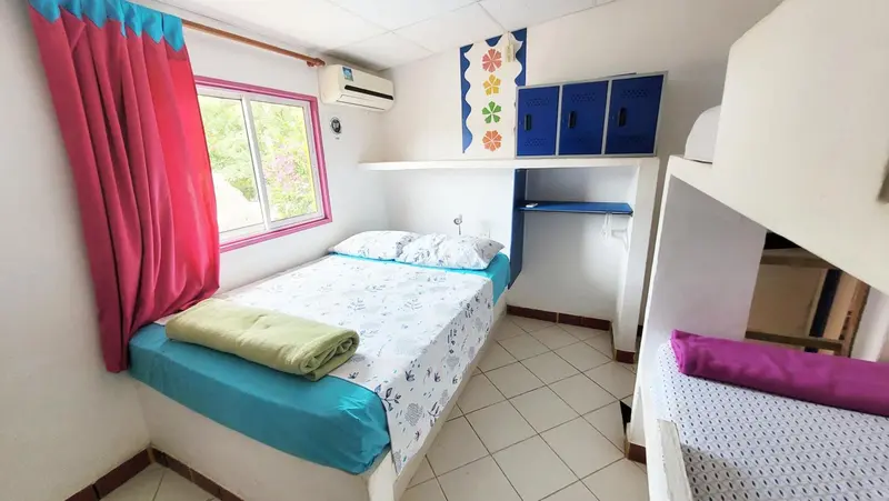 Une chambre avec un lit simple et un lit superposé.