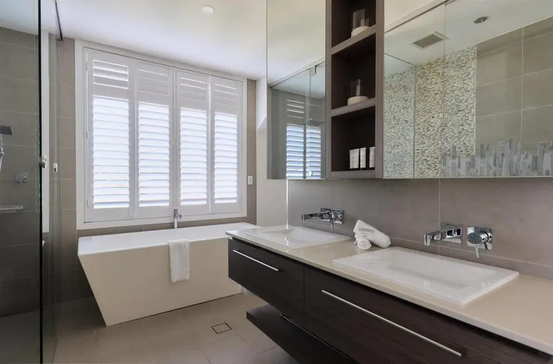 Une salle de bain moderne avec une baignoire et deux vasques.