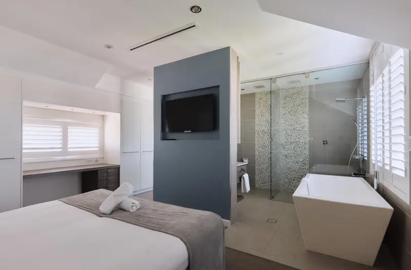 Une chambre moderne avec un lit et une salle de bain attenante.