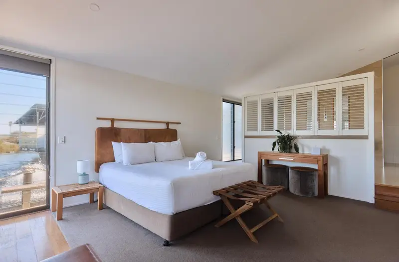 Une chambre lumineuse avec un grand lit et un accès à une terrasse.