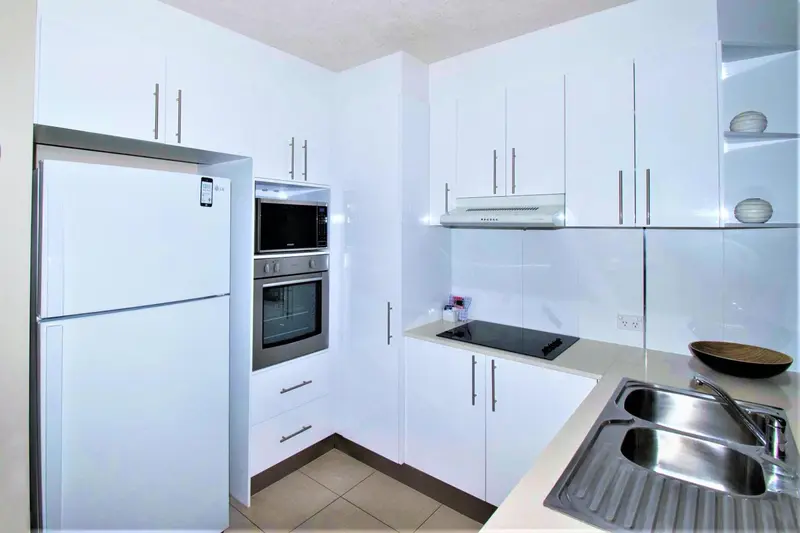 Cuisine moderne et lumineuse avec des appareils électroménagers en acier inoxydable.