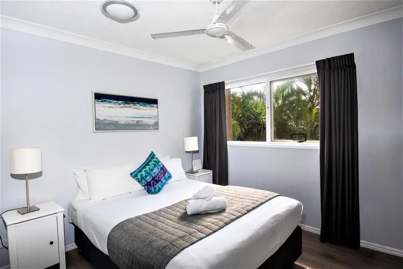 Une chambre lumineuse avec un grand lit et une décoration sobre.