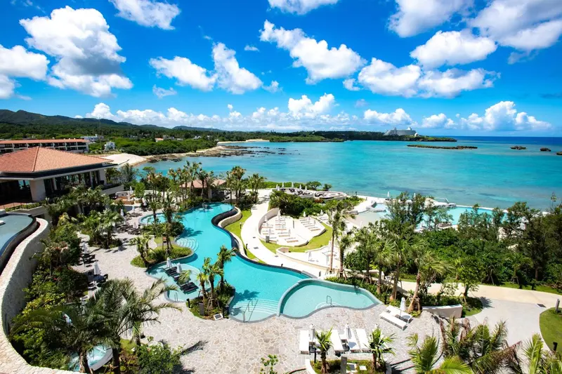 Vue aérienne d'un complexe hôtelier avec piscine et accès à la mer.