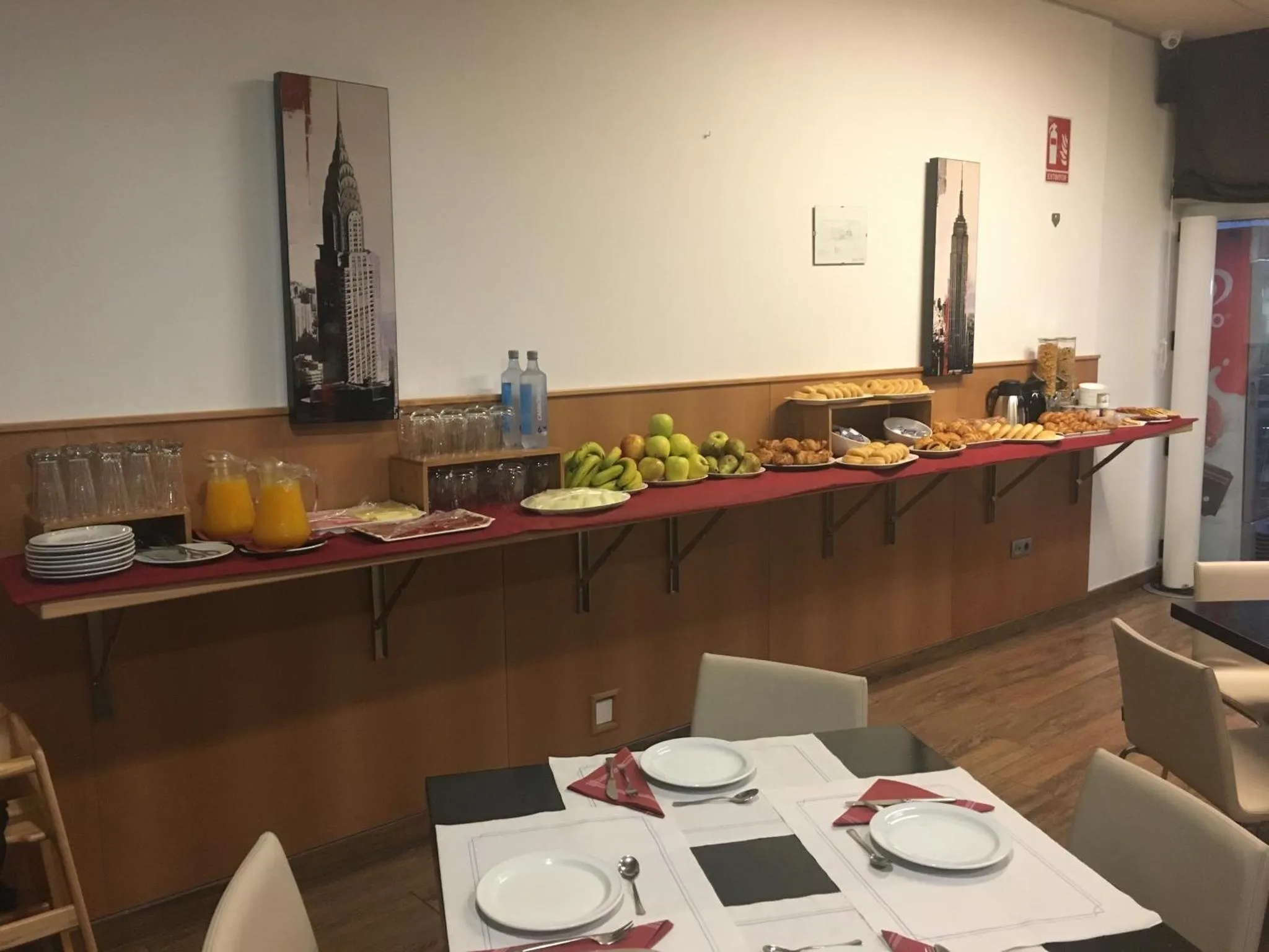 Un comptoir de buffet propose des boissons et des pâtisseries dans une salle lumineuse.