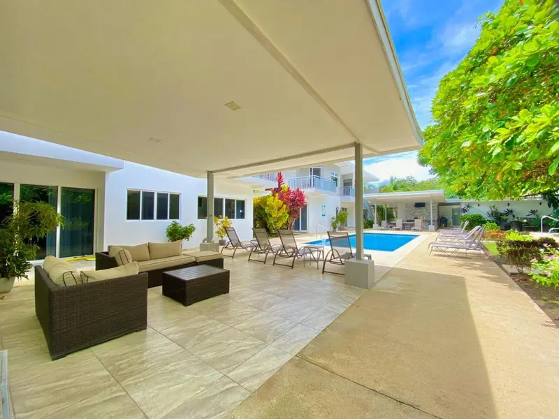 Espace de détente extérieur avec mobilier de jardin et piscine.