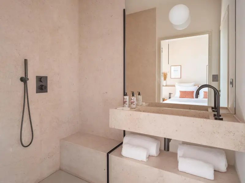 Une salle de bain minimaliste avec une douche à l'italienne et un lavabo intégré.