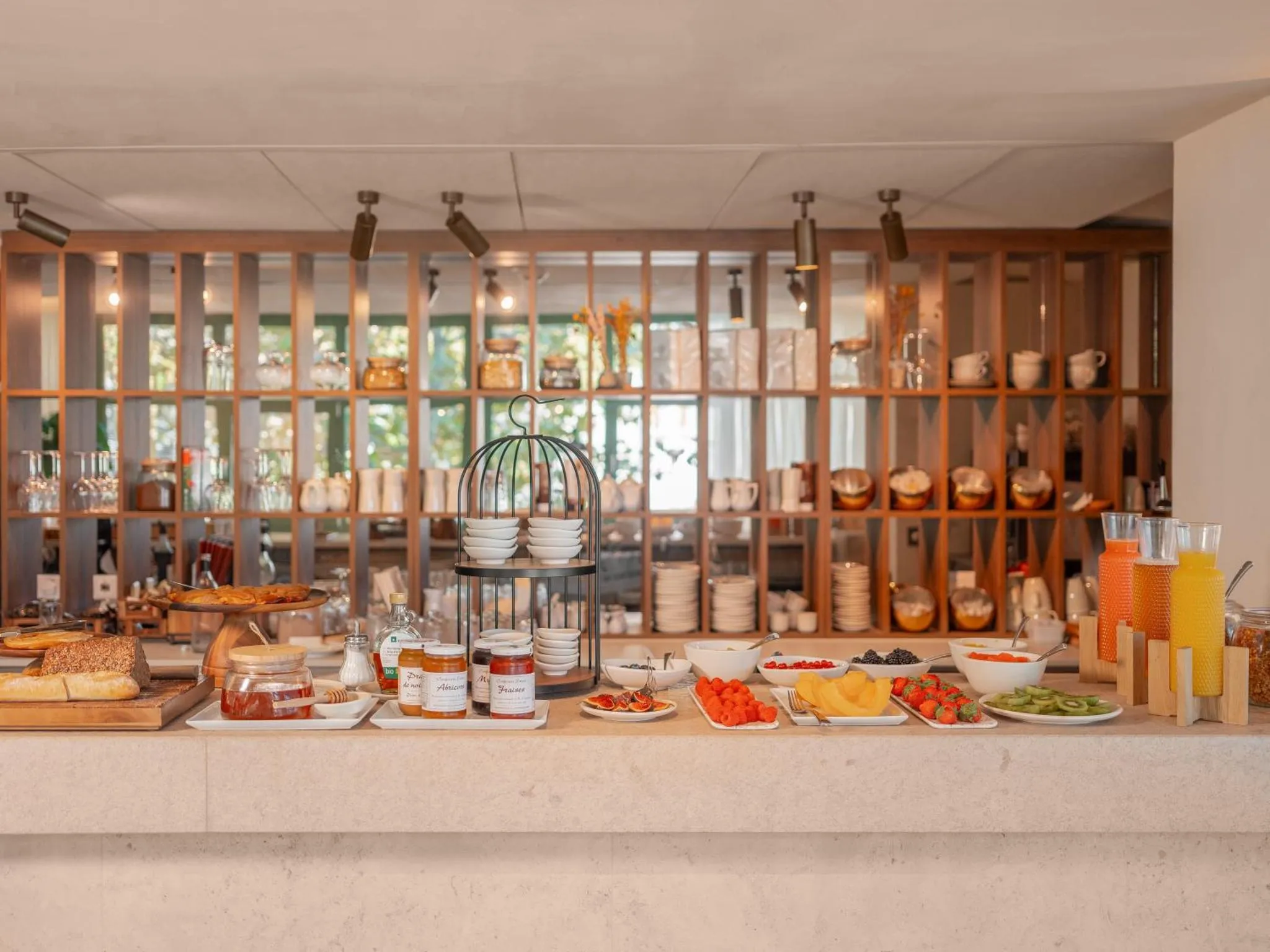 Un comptoir de buffet propose des fruits frais, des viennoiseries et des boissons.