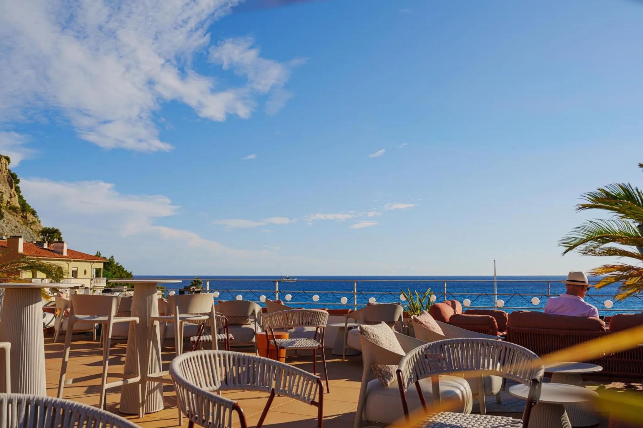 Terrasse aménagée avec mobilier d'extérieur face à la mer.