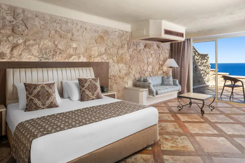 Une chambre lumineuse avec un grand lit et un coin salon.