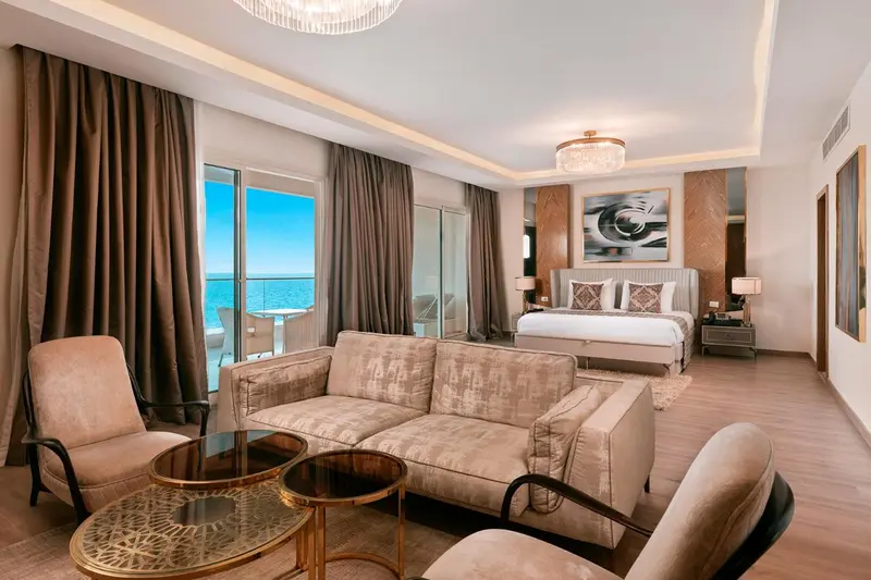 Espace de séjour lumineux avec canapés et vue sur la mer.