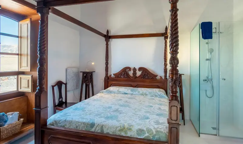 Une chambre à coucher avec un grand lit à baldaquin en bois sculpté.