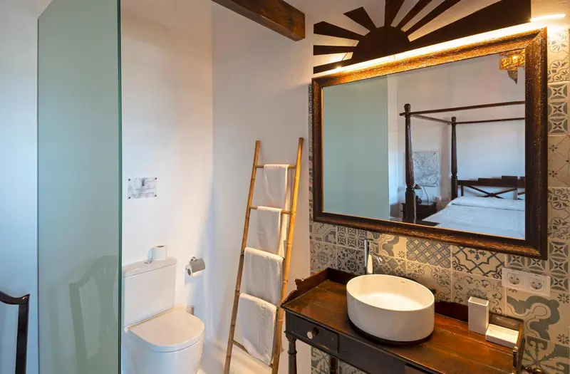 Une salle de bain lumineuse avec un lavabo surmeuble et un grand miroir.