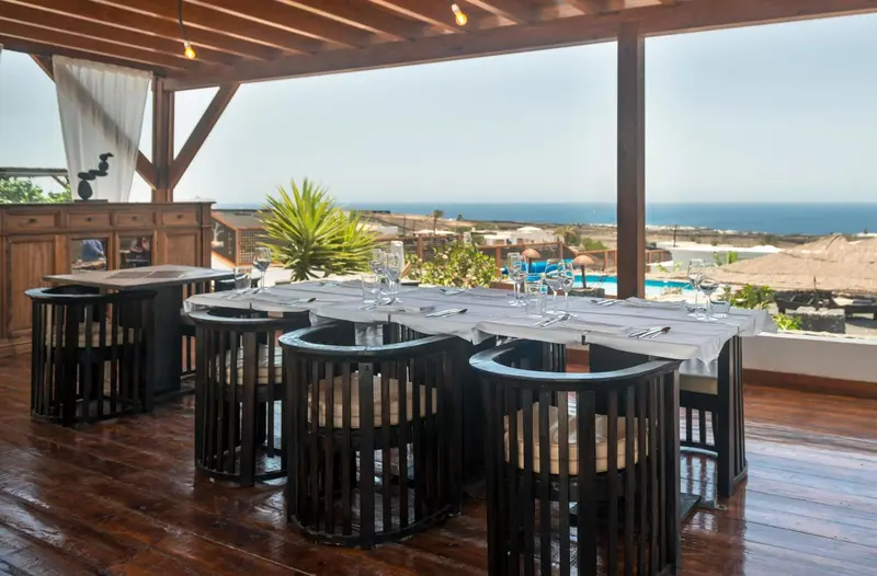 Une table dressée sur une terrasse avec vue sur la mer.
