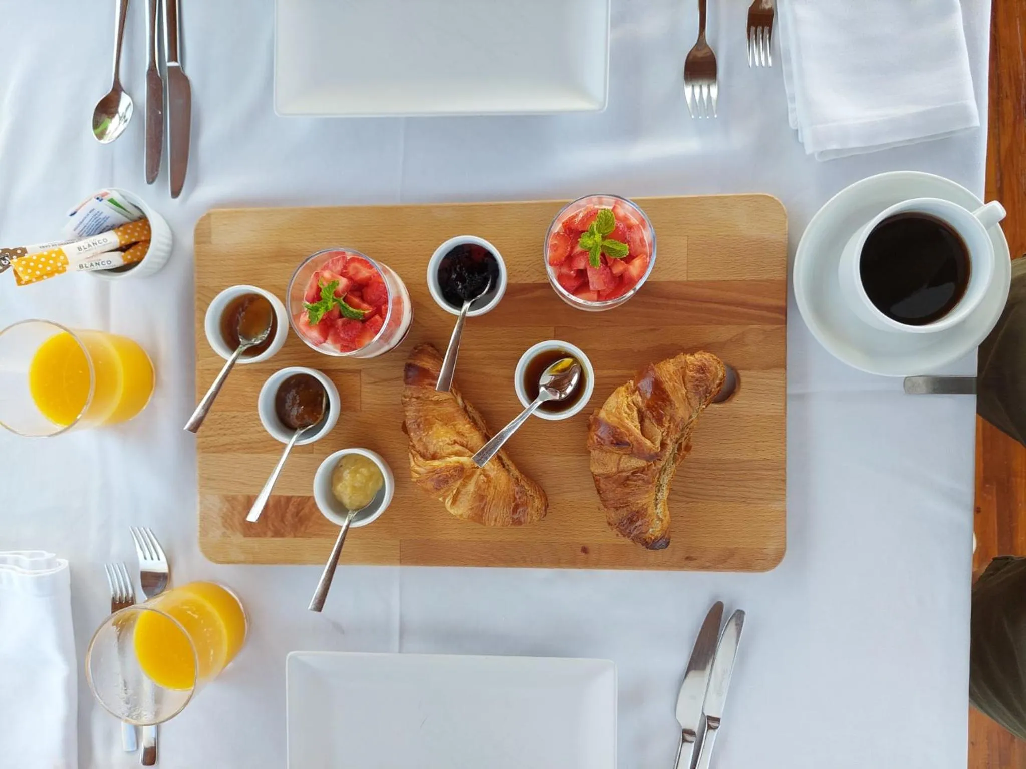 Un plateau de petit-déjeuner avec des viennoiseries, des fruits et des boissons.