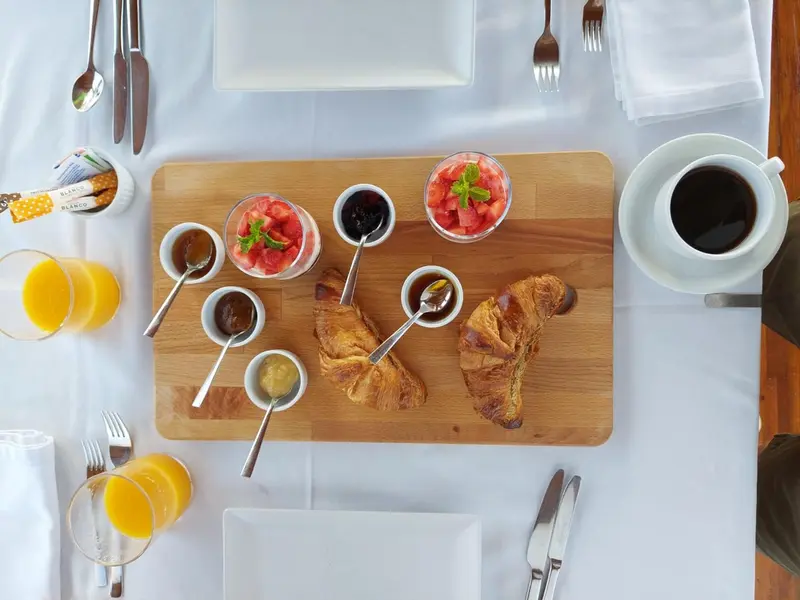 Un plateau de petit-déjeuner avec des viennoiseries, des fruits et des boissons.