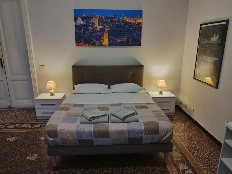 Une chambre à coucher avec un grand lit et une décoration murale représentant un paysage urbain.