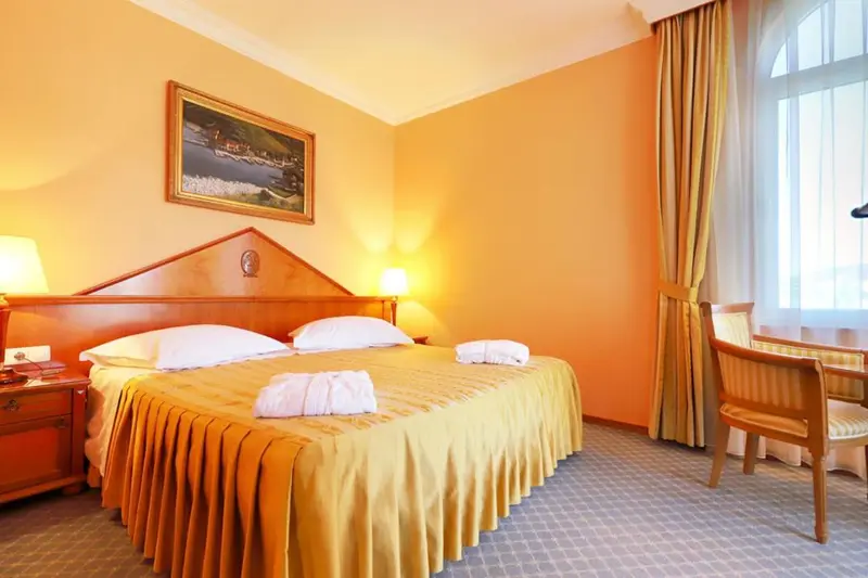 Une chambre lumineuse avec un grand lit et une fenêtre.