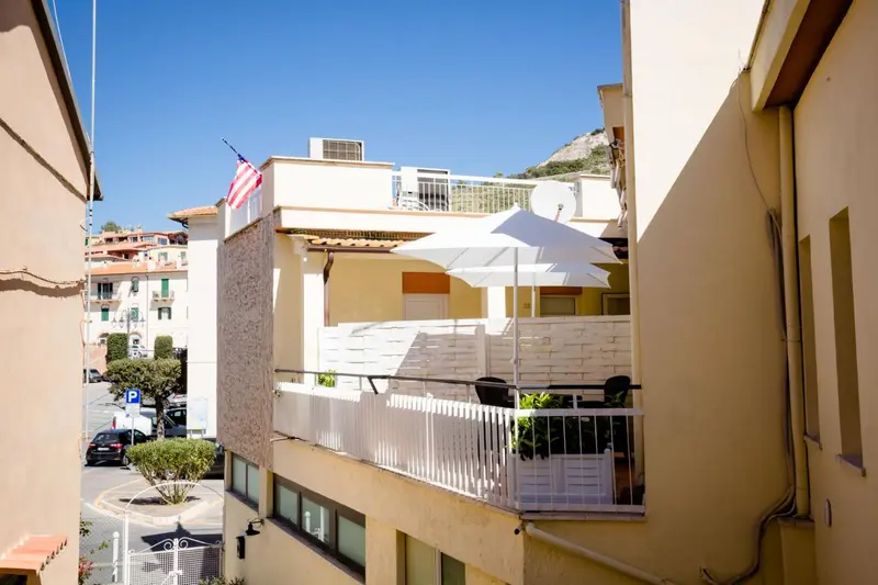 Terrasse avec parasols et mobilier de jardin, vue sur un paysage urbain.
