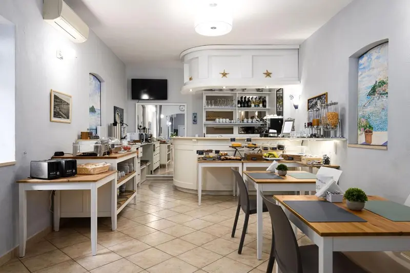 Une salle lumineuse avec un comptoir de buffet et des tables pour le petit-déjeuner.
