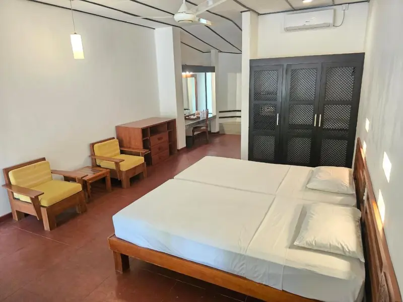Une chambre lumineuse avec un lit double et un coin salon.