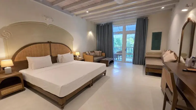 Une chambre lumineuse avec un grand lit et un espace détente.