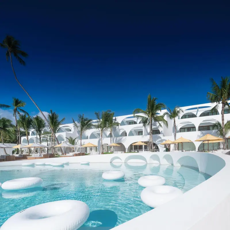 Piscine d'hôtel avec des bouées et des palmiers en arrière-plan.