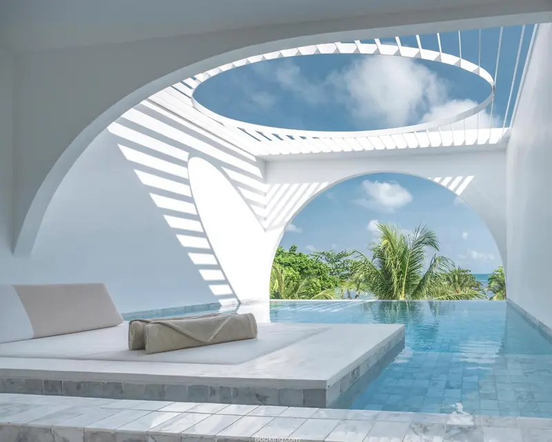 Une piscine à débordement offre une vue sur la mer et la végétation tropicale.