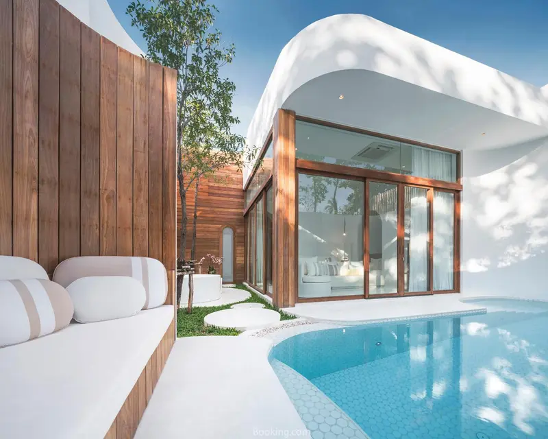 Terrasse avec salon et piscine turquoise au premier plan.