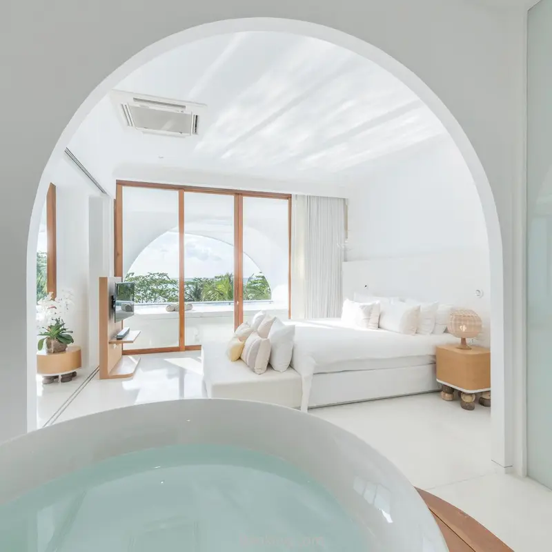 Une chambre lumineuse avec un grand lit et un accès à une vue extérieure.