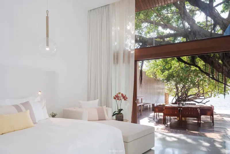 Une chambre lumineuse avec un lit confortable et une vue sur une terrasse verdoyante.
