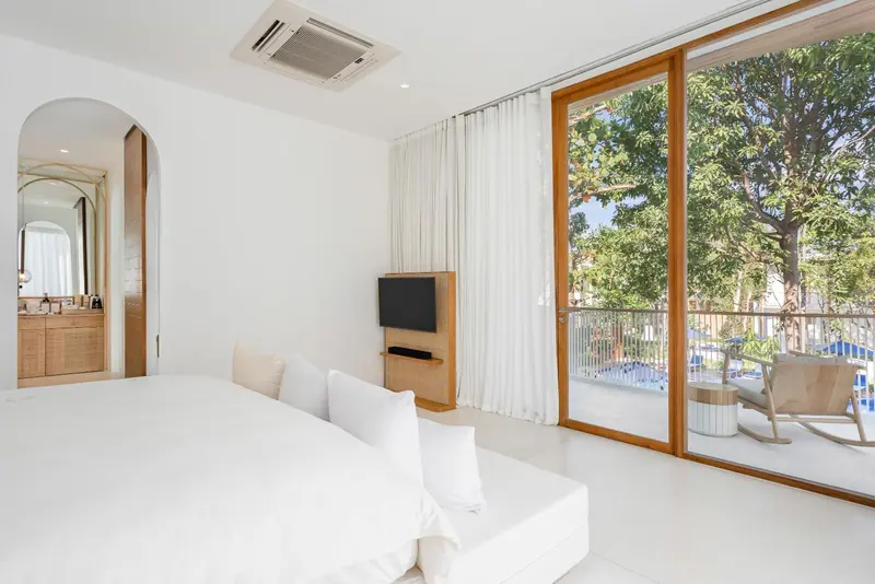 Une chambre lumineuse avec un grand lit et un accès à une terrasse.