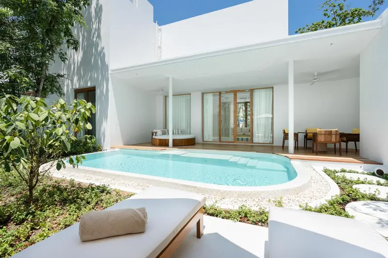 Une piscine privée s'ouvre sur une terrasse et un espace de détente.