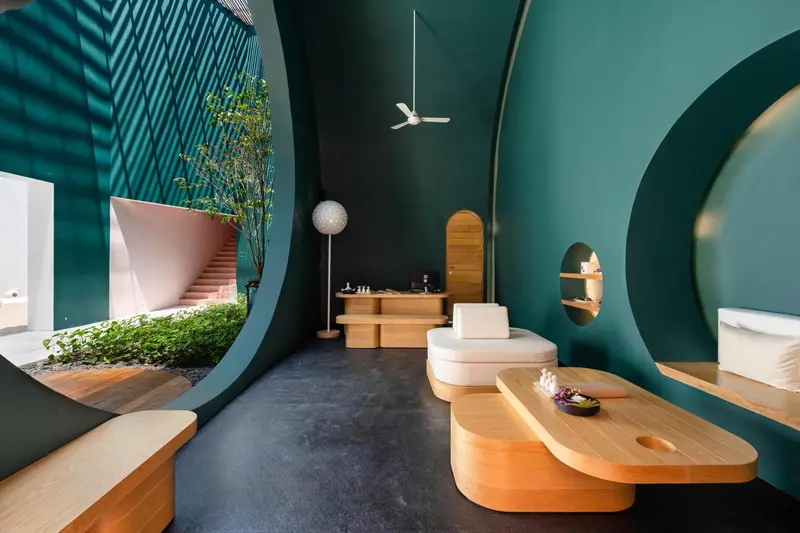 Espace de détente intérieur avec mobilier design et végétation.