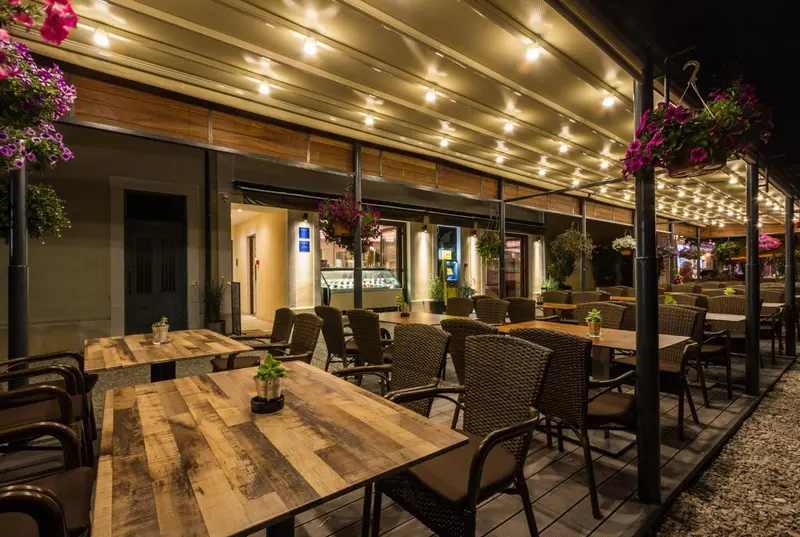 Terrasse lumineuse avec tables et chaises en osier.