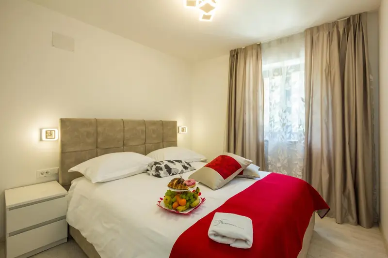 Une chambre avec un grand lit recouvert d'une courtepointe et de coussins.