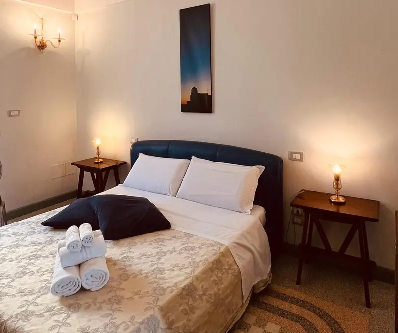 Une chambre lumineuse avec un grand lit recouvert d'une courtepointe et de coussins.