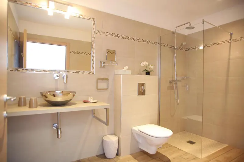 Une salle de bain moderne avec douche à l'italienne et vasque sur meuble.