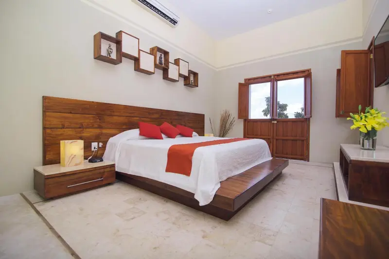 Une chambre lumineuse avec un grand lit et une décoration murale.