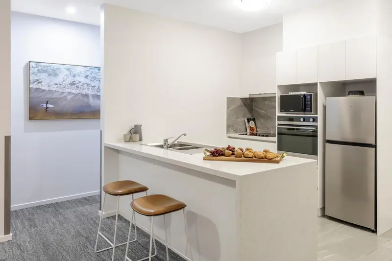 Une cuisine moderne avec un comptoir bar et des tabourets.
