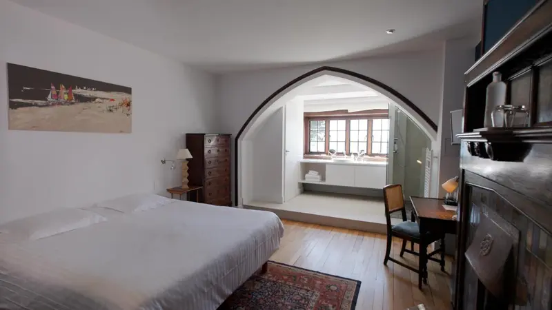 Une chambre lumineuse avec un lit et un bureau.